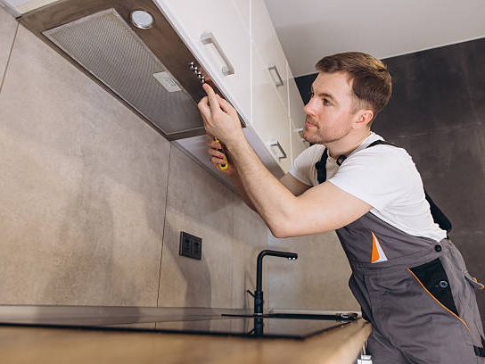 Professional technician servicing hood filters in a commercial kitchen